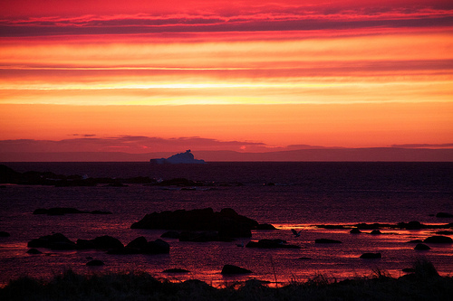 Sunset on the ocean with an iceberg